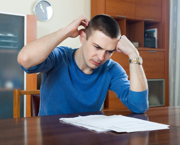 man-fills-financial-documents-min